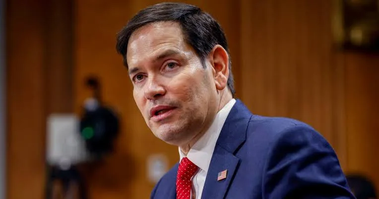 Marco Rubio speaking at a congressional hearing with visuals of Cuba and economic collapse themes representing U.S. policy debate.
